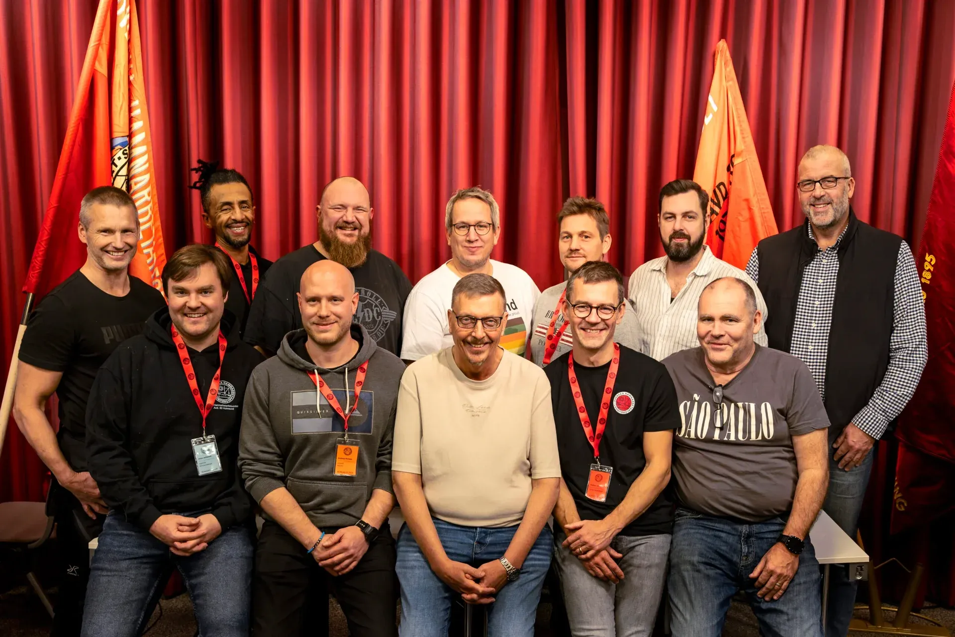 Gruppbild framför fanor och en röd ridå, från Hamnarbetarförbundets kongress 2024